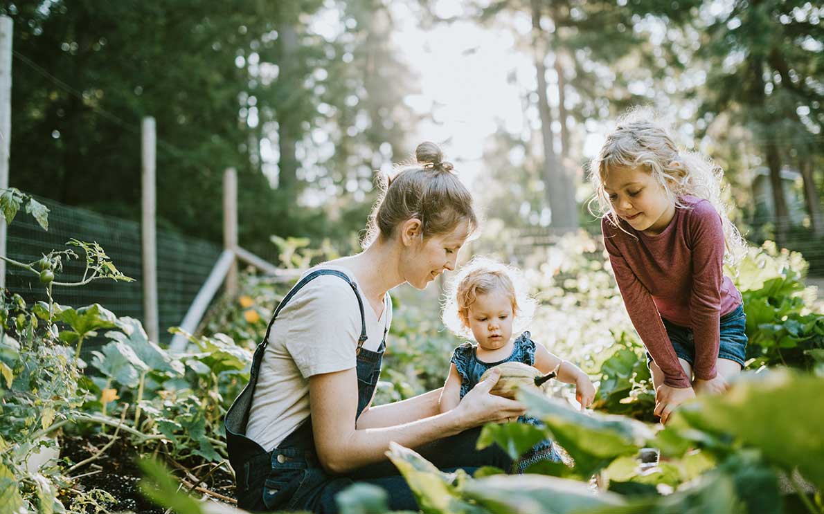 Mother and two little girls in a vegetable garden