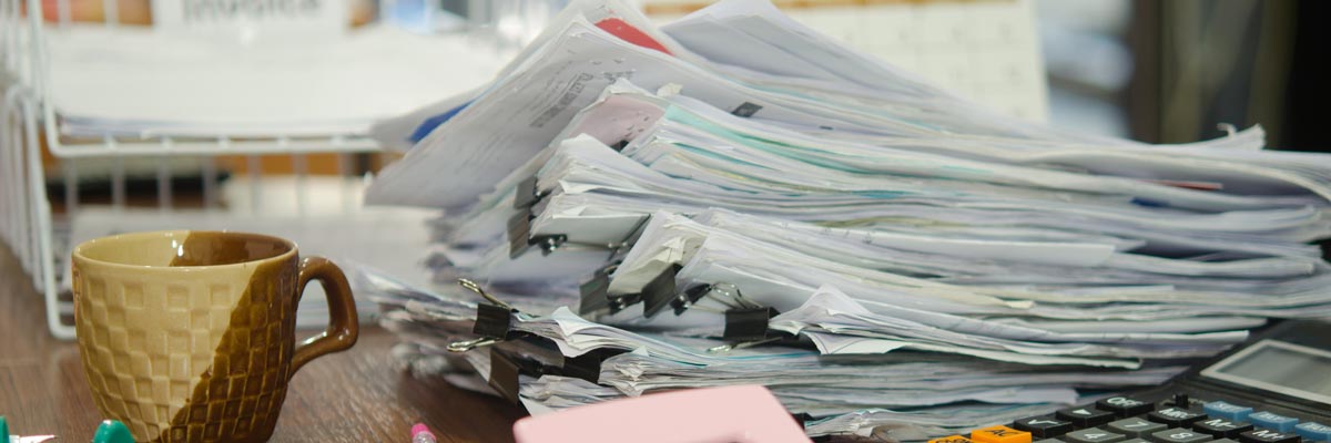 Pile of forms stacked messily on desk